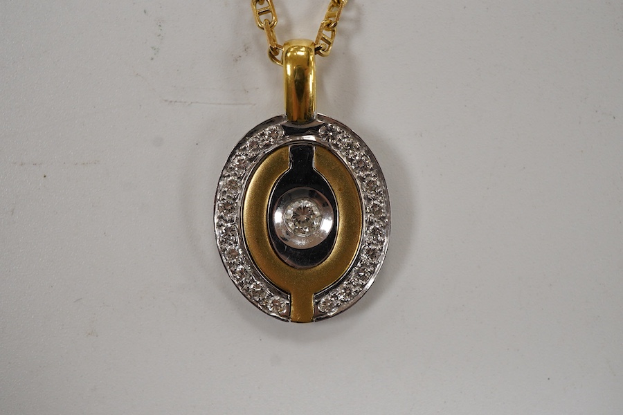 A yellow and white metal metamorphic oval pendant, with central diamond and diamond set border, closed 22mm, open 48mm, on an Italian 750 chain, 58cm, gross weight 16 grams.